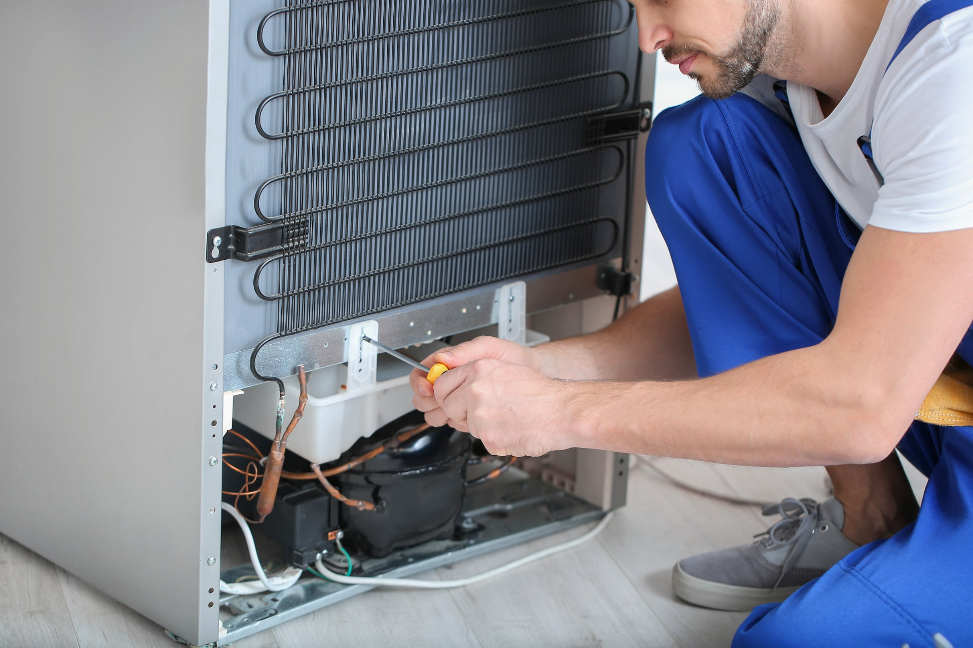 Técnico da Expressa reparando condensador de geladeira